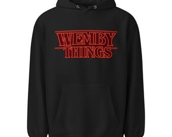 May include: Black hooded sweatshirt with a kangaroo pocket. The front features the red text "WEMBY THINGS" in a retro font. The hoodie has a drawstring hood and is made of a soft material.