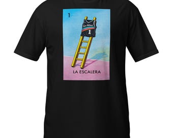 May include: Black t-shirt featuring a colorful graphic of a basketball jersey on a yellow ladder, with the text "LA ESCALERA" below. The jersey has the number 1 and the words "San Antonio" on it.