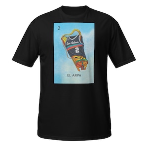 May include: Black t-shirt featuring a graphic of a harp with a basketball jersey design. The jersey reads "San Antonio" and the number "2". The image also includes the text "EL ARPA" and the number "2" at the top.