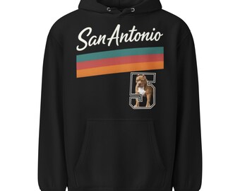 May include: Black hoodie with the text "San Antonio" in white script above a horizontal stripe of teal, red, and orange. Below the stripe is the number "5" in white with a brown and white dog inside.