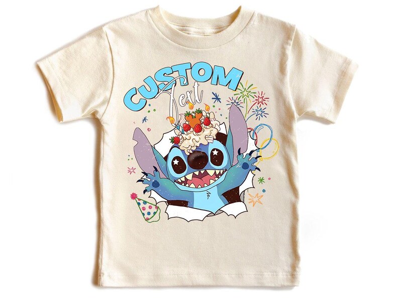 K&ouml;nnte beinhalten: Cremefarbenes T-Shirt mit einem blauen Cartoon-Charakter, der einen Nachtisch auf dem Kopf tr&auml;gt und aus einem zerrissenen Papiereffekt auftaucht. Der Text "CUSTOM Text" befindet sich &uuml;ber der Figur. Bunte Feuerwerke und Konfetti.