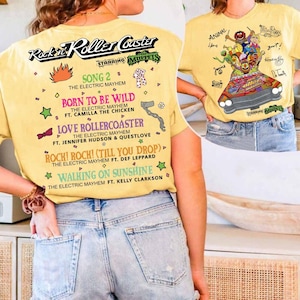 May include: Yellow t-shirt with "Rockin' Roller Coaster Starring The Muppets" printed on it. The front displays a Muppets graphic in a car. The back lists song titles including "Born to be Wild" and "Walking on Sunshine."