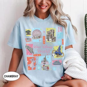 May include: Light blue t-shirt featuring a colorful collage of Walt Disney World icons, including the Spaceship Earth, Tower of Terror, and Cinderella Castle. The shirt has the text "Walt Disney World" and the year "1971".