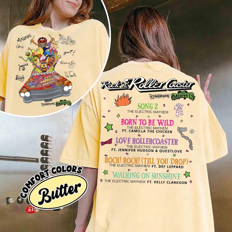 May include: Pale yellow t-shirt with a Muppets-themed graphic of a roller coaster and characters, with text including "Rockin' Roller Coaster" and song titles. The shirt also has the words "Comfort Colors" and "Butter".