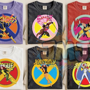 Puede incluir: Seis camisetas gráficas con personajes de Marvel X-Men. Las camisetas muestran a Cíclope, Gambito, Lobezno, Pícara, Jean Grey y Tormenta. Cada personaje está sobre un fondo circular colorido con su nombre encima. Las camisetas son de varios colores.