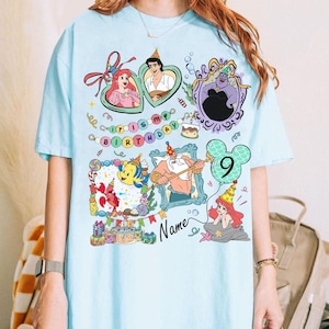 Puede incluir: Camiseta azul claro con ilustraciones de dibujos animados coloridos de personajes de La Sirenita, incluyendo a Ariel, el Pr&iacute;ncipe Eric, &Uacute;rsula y Flounder. La camiseta tiene el texto "It's My Birthday" y el n&uacute;mero "9".