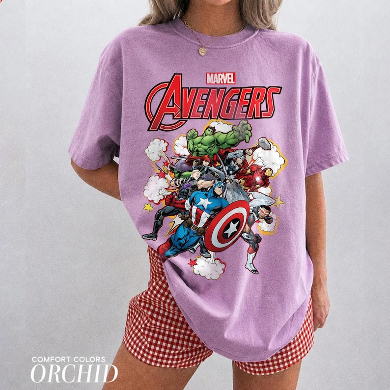 Pu&ograve; includere: Una t-shirt a maniche corte color viola chiaro con una stampa grafica dei personaggi Marvel Avengers, tra cui Hulk, Captain America e Iron Man. Il testo Marvel Avengers &egrave; stampato in rosso e bianco sopra i personaggi sul davanti.