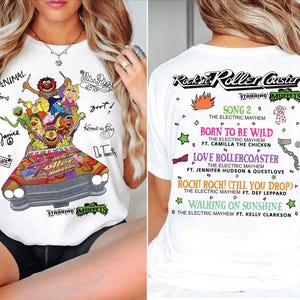 May include: White t-shirt with a vibrant graphic of the Muppets in a car, labelled "Rockin' Roller Coaster." The front has character signatures. The back lists song titles and artists. A fun, musical themed apparel item.