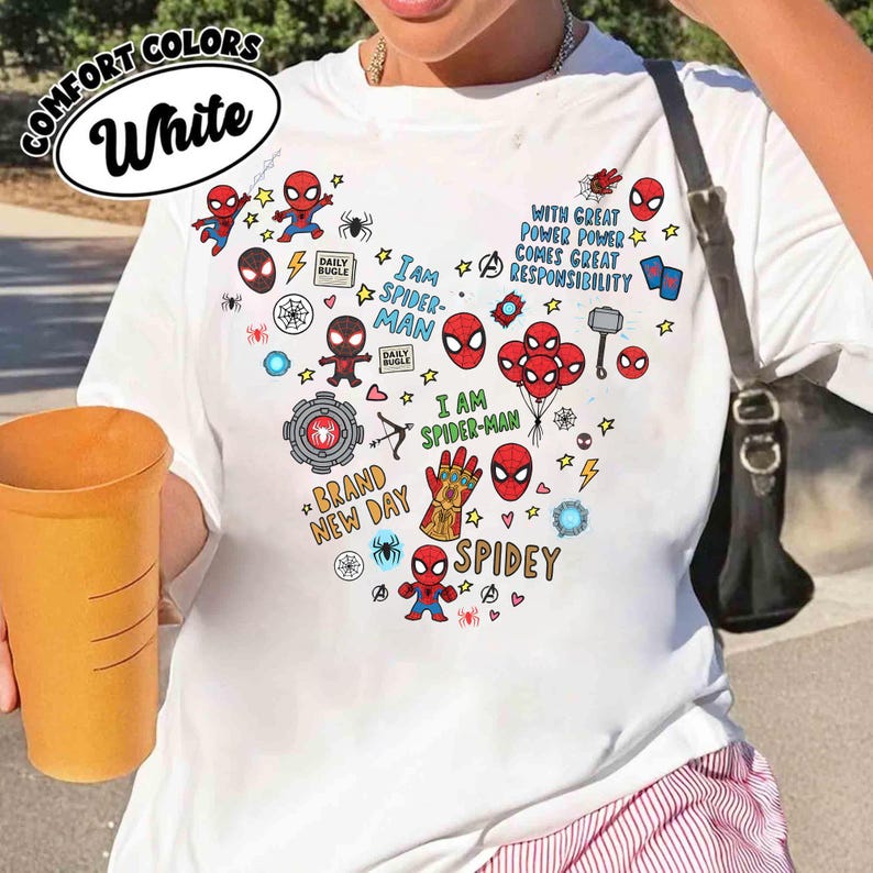 Puede incluir: Camiseta blanca con un dise&ntilde;o de Spider-Man en forma de coraz&oacute;n. El dise&ntilde;o incluye ilustraciones de Spider-Man, estrellas y frases como "I AM SPIDER-MAN" y "BRAND NEW DAY". La camiseta tambi&eacute;n tiene las palabras "COMFORT COLORS" y "White".
