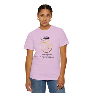 May include: A light purple t-shirt featuring the word "VIRGO" above a gold-colored Virgo symbol inside a gold circle. Below the symbol, the text reads "Making Lists is My Superpower."