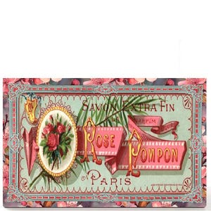 May include: A rectangular box with a vintage design featuring the words "Rose Pompon Paris". The design includes a floral border, an oval with roses, and pink banners. The color palette includes pink, green, and gold.