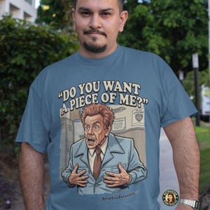May include: A blue t-shirt featuring the text "DO YOU WANT A PIECE OF ME?" and a cartoon image of a man in a blue suit. The design is in a retro style, with the RetroStarPortraits logo at the bottom.