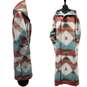 May include: A long, hooded coat with a geometric pattern in shades of red, orange, blue, and grey. The coat has a shawl collar and two pockets.
