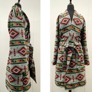 May include: A long, grey robe with a geometric pattern in shades of red, orange, green, blue, and black. The robe has a shawl collar and a tie belt.