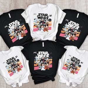 May include: Black and white t-shirts featuring a Star Wars graphic with Disney characters. The design includes the text "STAR WARS" and a colorful illustration of characters like Mickey Mouse, Donald Duck, and others. The shirts are short-sleeved.