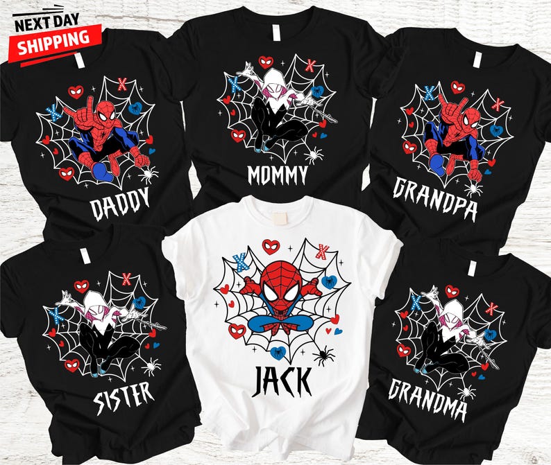 Op de afbeelding: Zwarte en witte t-shirts met Spider-Man en Spider-Gwen ontwerpen, samen met de woorden "Daddy", "Mommy", "Grandpa", "Sister", "Jack" en "Grandma". De shirts hebben een webdesign met harten en spinnen.