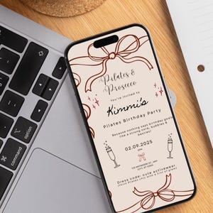 May include: A smartphone displays a Pilates birthday party invitation. The invitation features the text "Pilates & Prosecco" and "Kimmi's Pilates Birthday Party." The design includes bow illustrations and the date 02.09.2025.