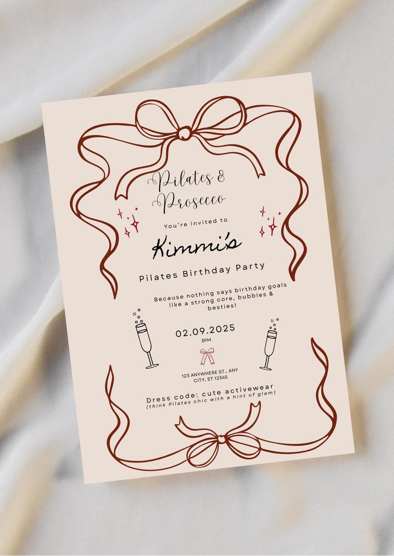 May include: A beige invitation with brown ribbon and text. The text reads "Pilates & Prosecco" and "Kimmi's Pilates Birthday Party." The date is 02.09.2025, with a dress code of cute activewear.