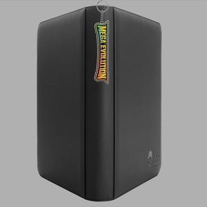 May include: A black, rectangular binder with the text "MEGA EVOLUTION" in a colorful, stylized font on the spine. A small metal ring is attached to the top. The binder has a smooth, matte finish.