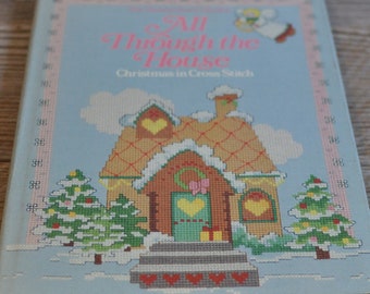 May include: A book titled "All Through the House: Christmas in Cross Stitch" with a cover illustration of a gingerbread house with snow on the roof, two Christmas trees, and a pink angel in the sky.
