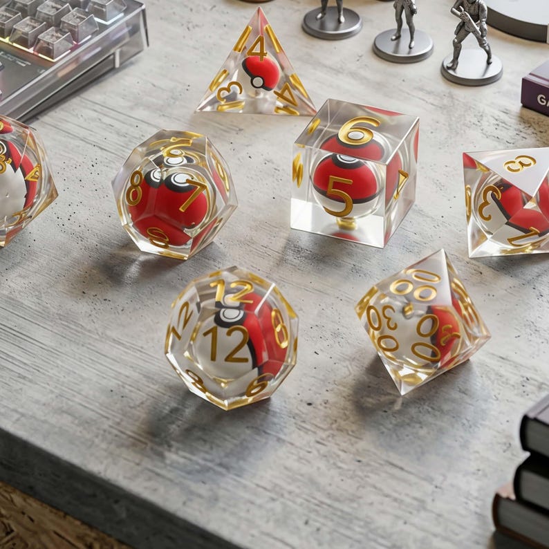May include: A set of polyhedral dice made of clear resin, each containing a miniature red and white spherical object inside. The dice feature gold-colored numbers etched into the surfaces, including a d4, d6, d8, d10, d12, and a d20 die.