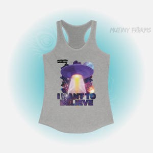 Op de afbeelding: Een grijze tanktop met een paars UFO-ontwerp, een heldere lichtstraal, planeten en de tekst "I WANT TO BELIEVE" in kleurrijke letters. De tanktop heeft het "MUTINY FARMS" logo.