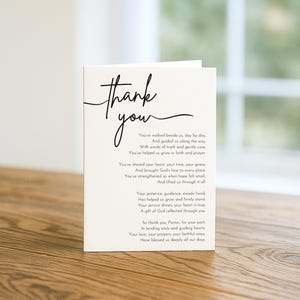Puede incluir: Una tarjeta de agradecimiento de color crema con texto en escritura negra. La tarjeta presenta las palabras "thank you" en una escritura fluida en la parte superior, con un poema debajo. La tarjeta está sobre una superficie de madera.