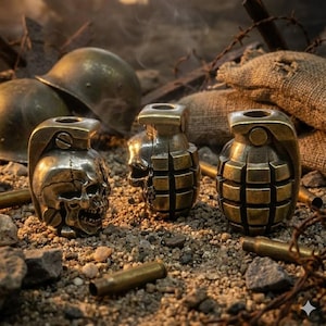 May include: Three bronze-colored grenade-shaped objects, one with a skull design, rest on a bed of small rocks and gravel. Two military helmets are visible in the background, along with spent bullet casings and a burlap sack.