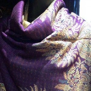 Può includere: Uno scialle viola con un motivo paisley in oro e blu. Lo scialle è realizzato in un tessuto morbido e leggero, perfetto per aggiungere un tocco di eleganza a qualsiasi outfit.