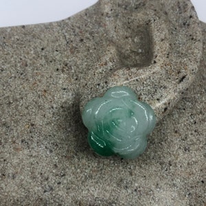 Op de afbeelding: Een gegraveerde jade rozenhanger in tinten groen. De roos is realistisch gegraveerd met delicate details.