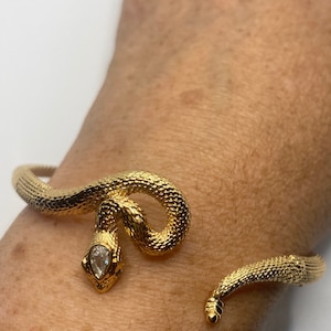 Pulsera vintage con forma de serpiente y ojos de cristal verde rellenos de oro