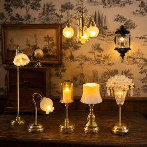 May include: A collection of miniature dollhouse lighting fixtures including a brass chandelier, a black wall sconce, and several table lamps with gold-toned bases, frosted glass shades, and clear crystal-style accents, all emitting a warm glow.