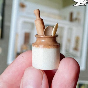 May include: Miniature kitchen utensil holder with a rolling pin and spoons. The holder is white with a brown rim. The text "digital file" is in a banner above the holder.