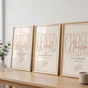 Puede incluir: Tres láminas de arte mural enmarcadas verticales con fondo beige. Las impresiones muestran las palabras Blessed, Loved y Chosen en una fuente grande con contorno, con texto cursivo debajo, incluyendo los versículos bíblicos Ephesians 1:3, Romans 5:8 y 1 Peter 2:9.