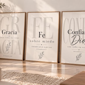 Puede incluir: Tres láminas decorativas verticales enmarcadas con fondo crema y texto negro. Los cuadros muestran frases religiosas en español como Gracia, Fe y Confía en Dios, acompañadas de pequeñas ilustraciones de hojas y citas de versículos bíblicos.