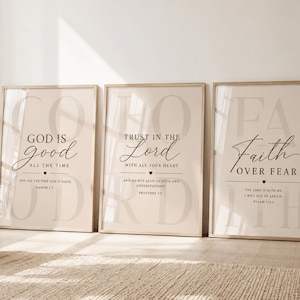 May include: Three rectangular framed wall art prints with light beige backgrounds and black text. The first print reads God is good all the time, the second reads Trust in the Lord with all your heart, and the third reads Faith over fear.