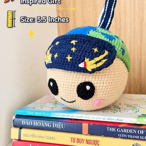 May include: A handmade crochet plush inspired by the Artemis II space mission. The plush is beige with a blue and green cap featuring stars and a rocket. It measures 5.5 inches.