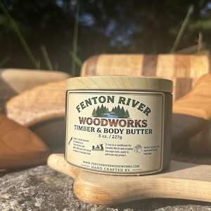 May include: A cylindrical container of Fenton River Woodworks Timber & Body Butter, 8 oz. / 227g. The label features a forest and river graphic, text, and instructions for use as a conditioner for somatic blocks, scraping, and massage tools.