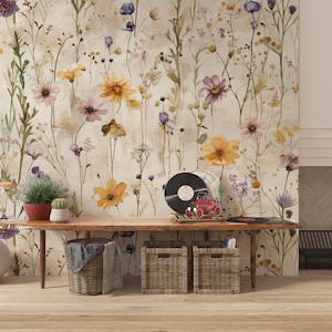 Puede incluir: Una habitaci&oacute;n con papel pintado floral y una mesa de madera. La mesa exhibe un tocadiscos, discos, plantas y cestas. La paleta de colores incluye beige, marr&oacute;n, amarillo, morado y verde.