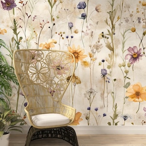 Puede incluir: Una silla de rat&aacute;n tejido con un coj&iacute;n blanco se encuentra frente a un papel pintado floral. El papel pintado presenta flores de acuarela en tonos morados, naranjas y amarillos, con tallos y hojas verdes. Una planta en maceta est&aacute; a la izquierda.