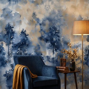 May include: A cozy interior scene featuring a navy blue armchair with a mustard-colored throw blanket. The backdrop is a watercolor-style mural in shades of blue and tan, depicting a forest scene. A floor lamp and side table with decor complete the room.
