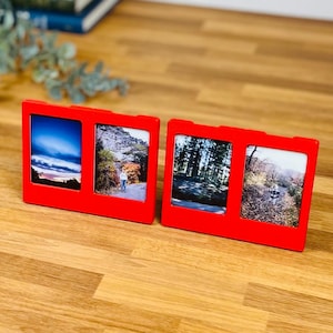 May include: Two bright red rectangular frames, each containing two vertical photo slots. The left frame displays a sunset landscape and a person on a path, while the right frame shows a forest scene and a person walking on a leaf-covered trail.