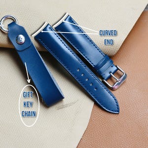 May include: A navy blue leather gift key chain and two navy blue watch straps with silver buckles. The watch straps have a curved end design. The key chain has a silver ring and a snap closure.
