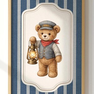 May include: A framed print showing a teddy bear in a train conductor's outfit, holding a lantern. The bear has a striped cap, waistcoat, and red neckerchief. The background has blue and white vertical stripes. The frame is wooden.