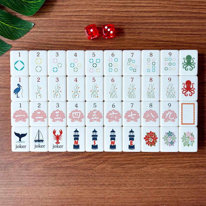 May include: A set of white Mahjong tiles with various symbols and numbers, including octopuses, flowers, and lighthouses. Two red dice are also present. The tiles are arranged on a wooden surface.