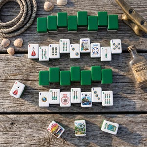 May include: A set of nautical-themed mahjong tiles featuring illustrations of sailboats, lighthouses, anchors, and oars. The tiles are white with green backs, displayed alongside a small glass bottle labeled Dockmaster's Whiskey and seashells.