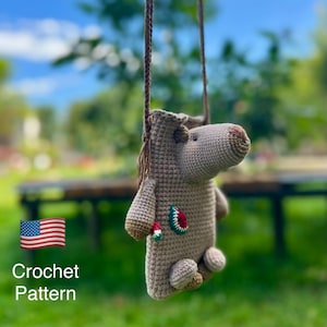 Könnte beinhalten: Eine gehäkelte, hellbraune pferdeförmige Tasche mit langem Riemen. Die Tasche hat einen detaillierten Kopf, Beine und einen kleinen dekorativen Aufnäher. Der Text "Crochet Pattern" ist unten im Bild zu sehen.