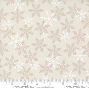 May include: Cream-colored fabric with a repeating pattern of snowflakes in white and light brown. The snowflakes are detailed with intricate designs. A ruler is along the bottom edge.