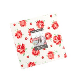 May include: Moda Fabrics Signature by Camille Roskelley fabric bundle featuring a white background with a red rose pattern. The bundle includes a label with the text "Moda Fabrics Signature by Camille Roskelley".