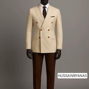 Może przedstawiać: Beżowy dwurzędowy garnitur z brązowymi spodniami, białą koszulą i ciemnobrązowym krawatem. Garnitur ma poszetkę i jest prezentowany na manekinie. Widoczny jest tekst "HUSSAINBYANAS".